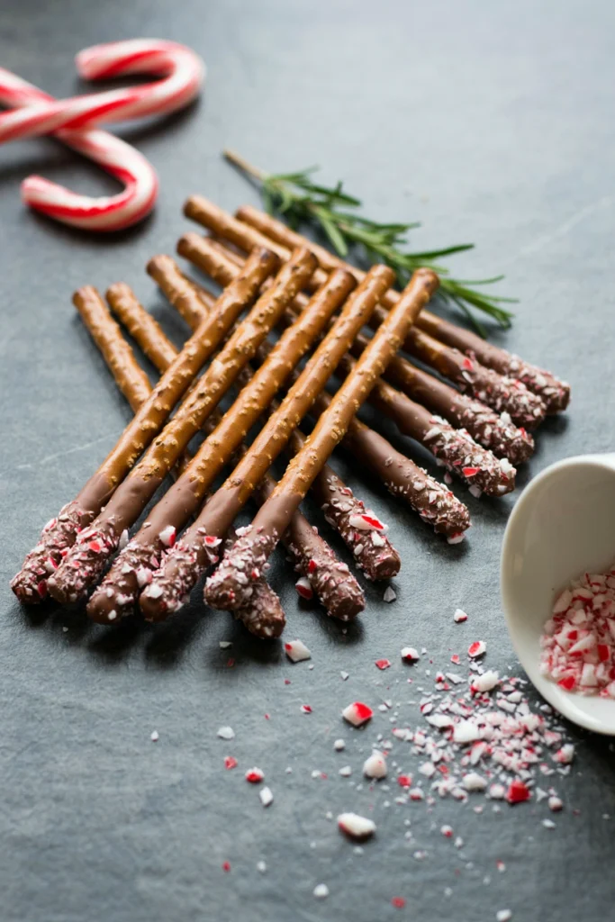 Chocolate-dipped pretzel rods rolled in crushed candy cane pieces
