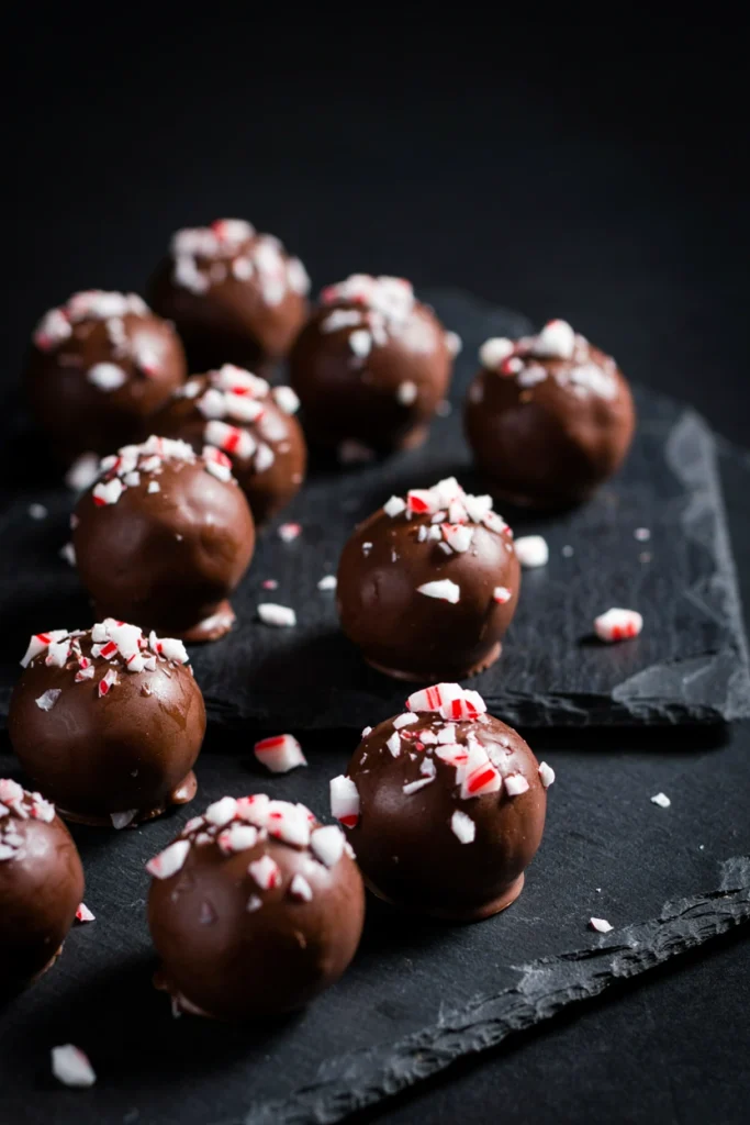  Round chocolate truffles topped with crushed candy cane on a serving plate