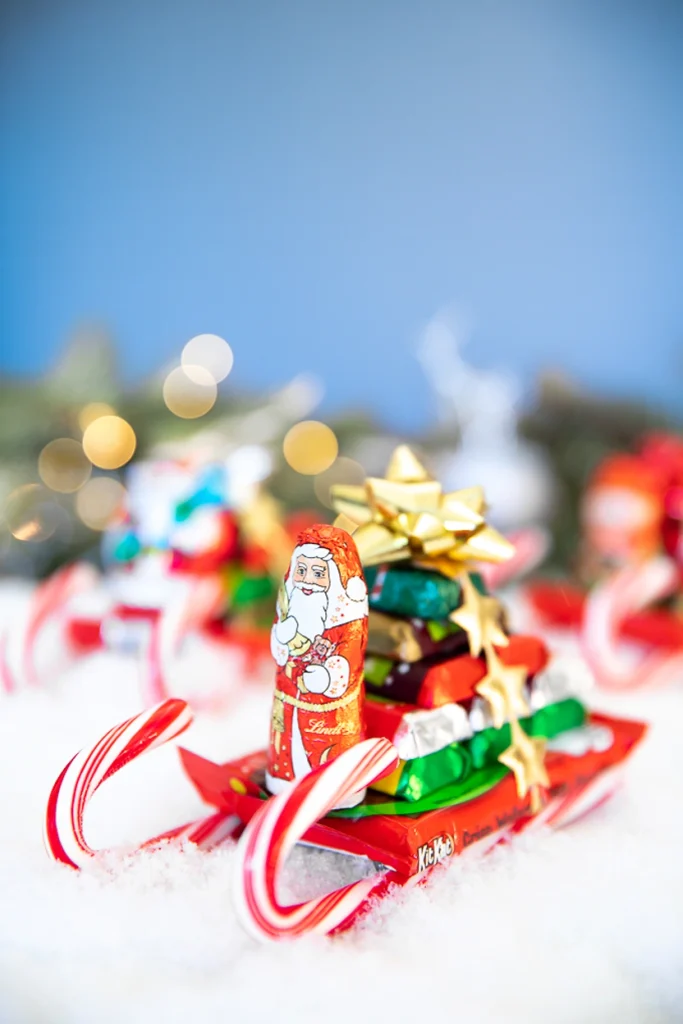 Mini sleighs made from two candy canes, a chocolate square, and candy passengers