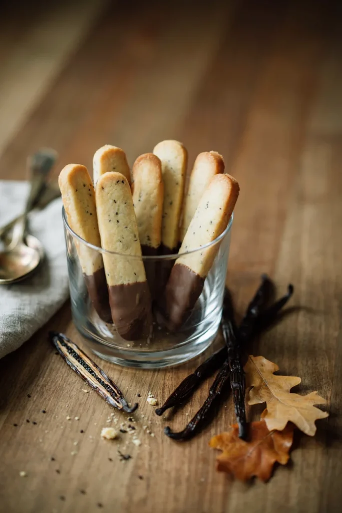 Chocolate-dipped vanilla bean shortbread cookie fingers standing in a glass