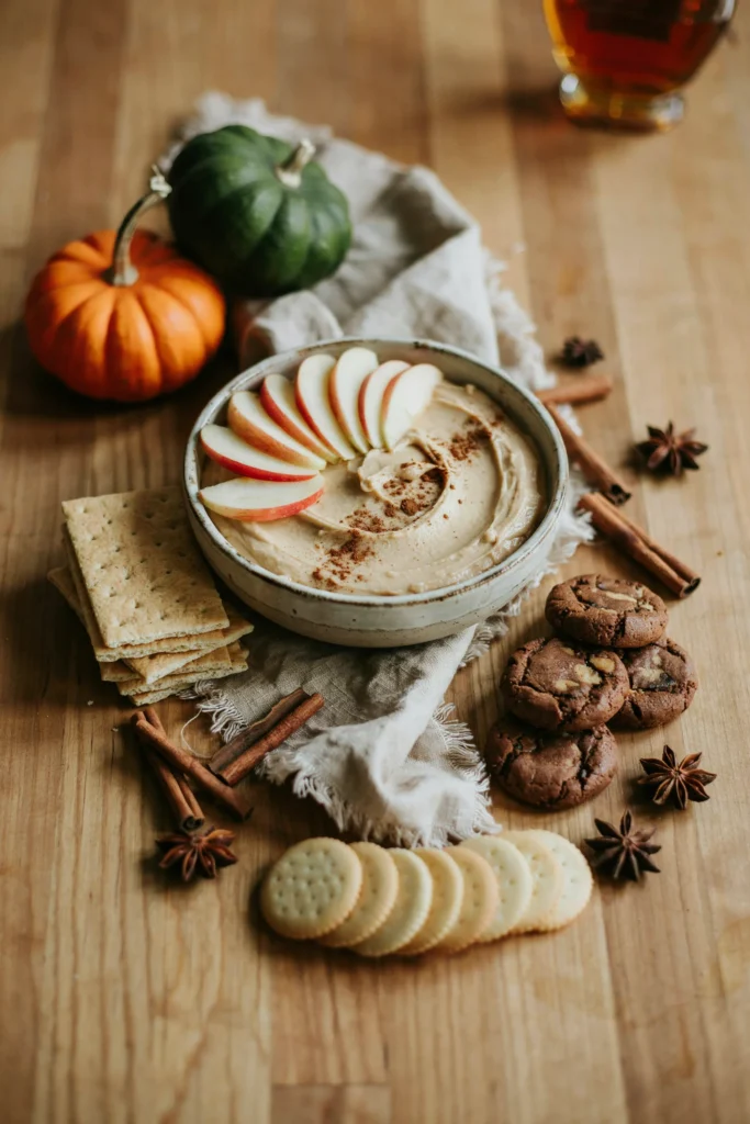 Bowl of pumpkin cheesecake dip served with graham crackers and apple slices