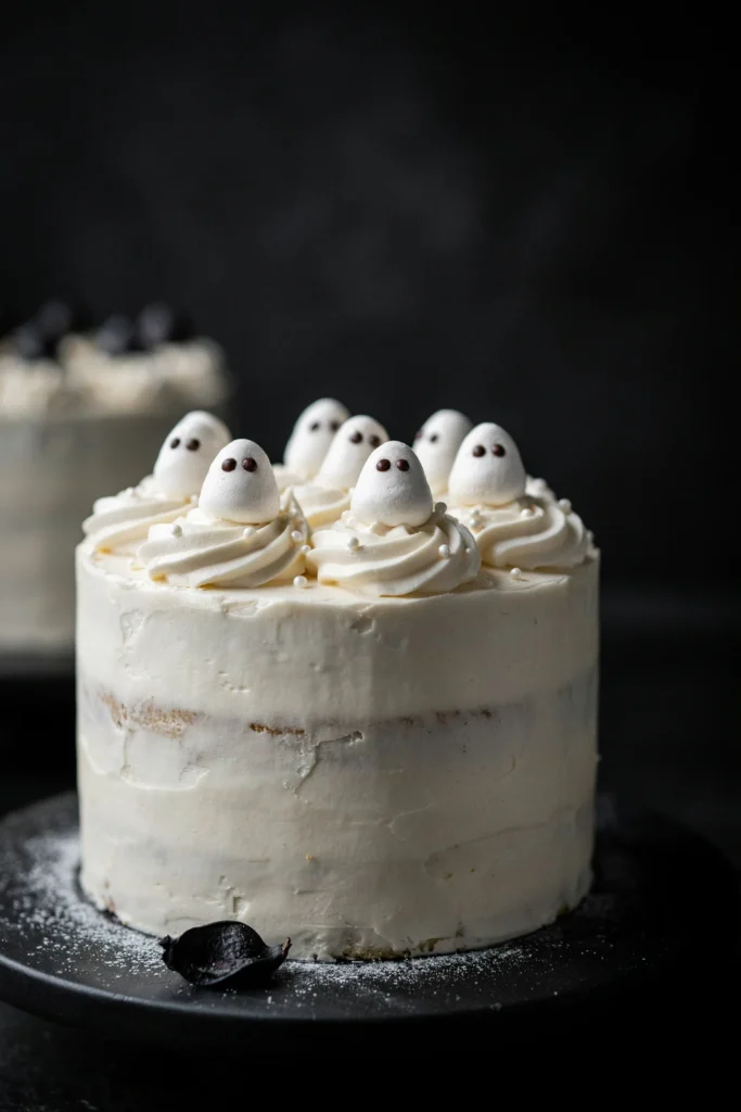 White layer cake frosted with marshmallow buttercream and piped ghost shapes