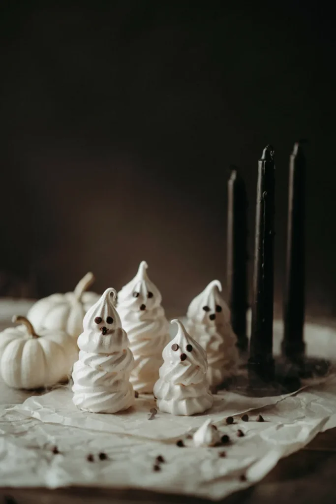Piped meringue ghost cookies with chocolate chip eyes