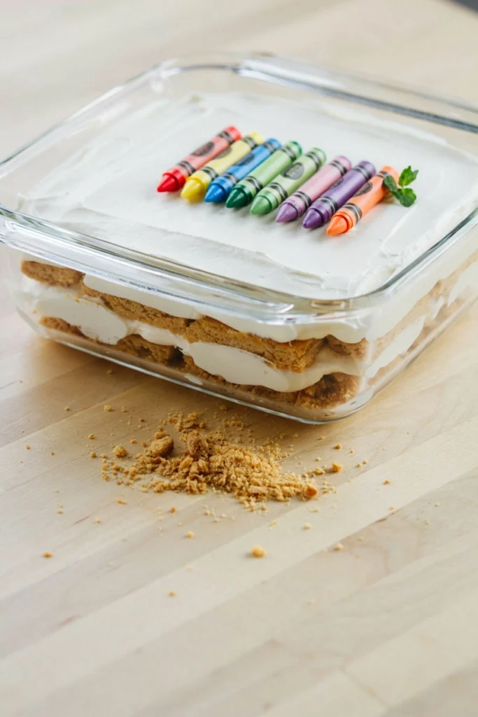 No-bake crayon box icebox cake topped with rainbow fondant crayons