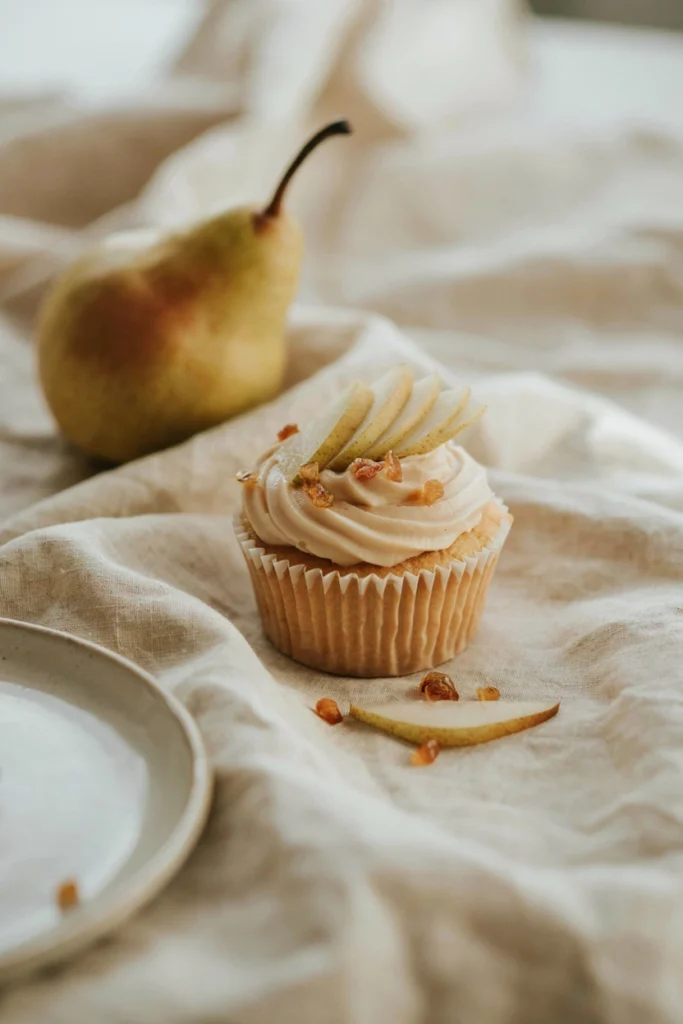 Pear and ginger cupcake topped with vanilla-ginger buttercream and a fresh pear slice