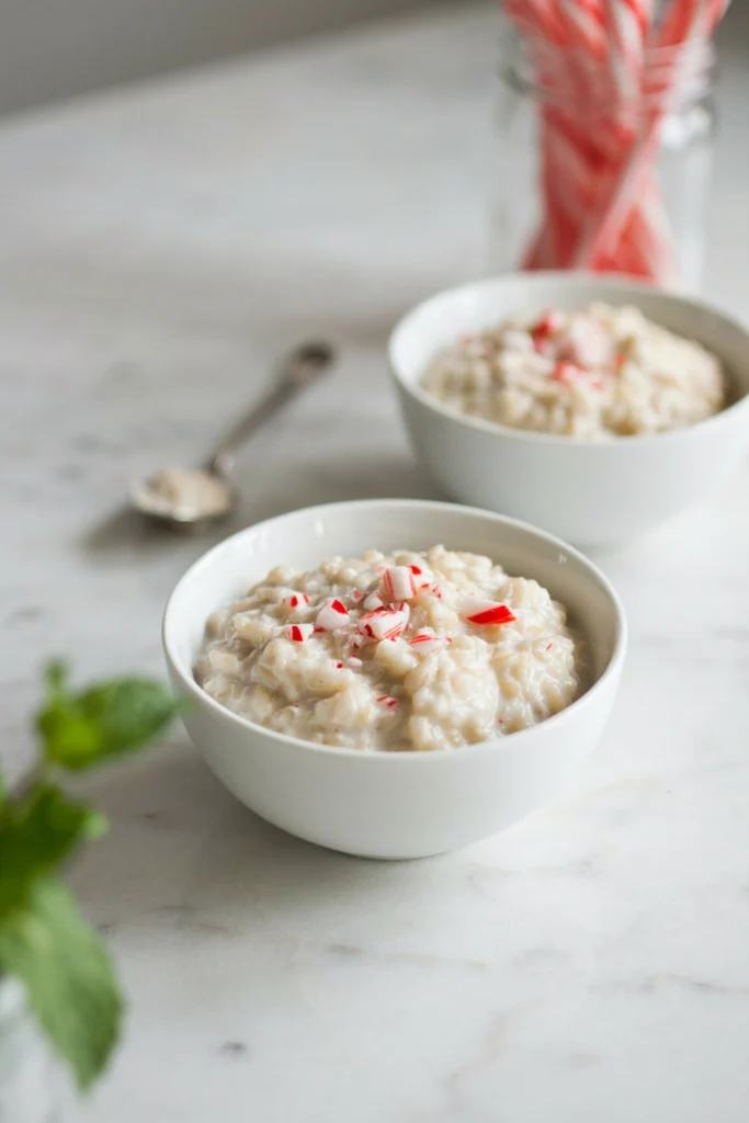 Creamy peppermint rice pudding in bowls topped with crushed candy cane