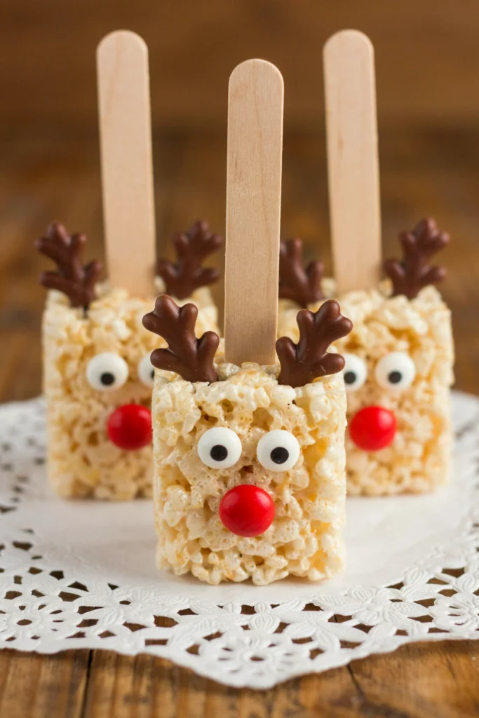 Chocolate-coated Rice Krispie treat pops decorated as reindeer, standing upright in a styrofoam block