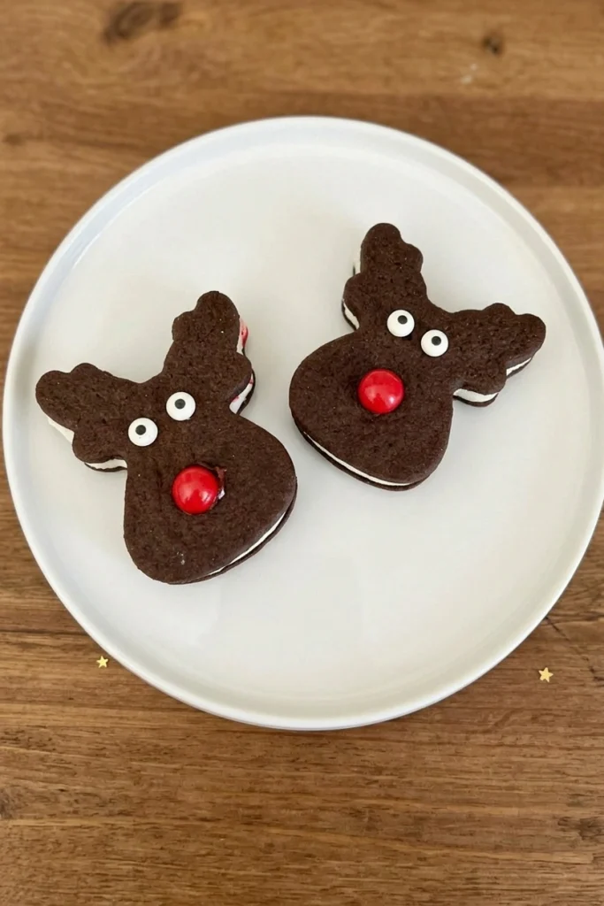 Vanilla ice cream sandwiched between chocolate cookies decorated as reindeer with pretzel antlers