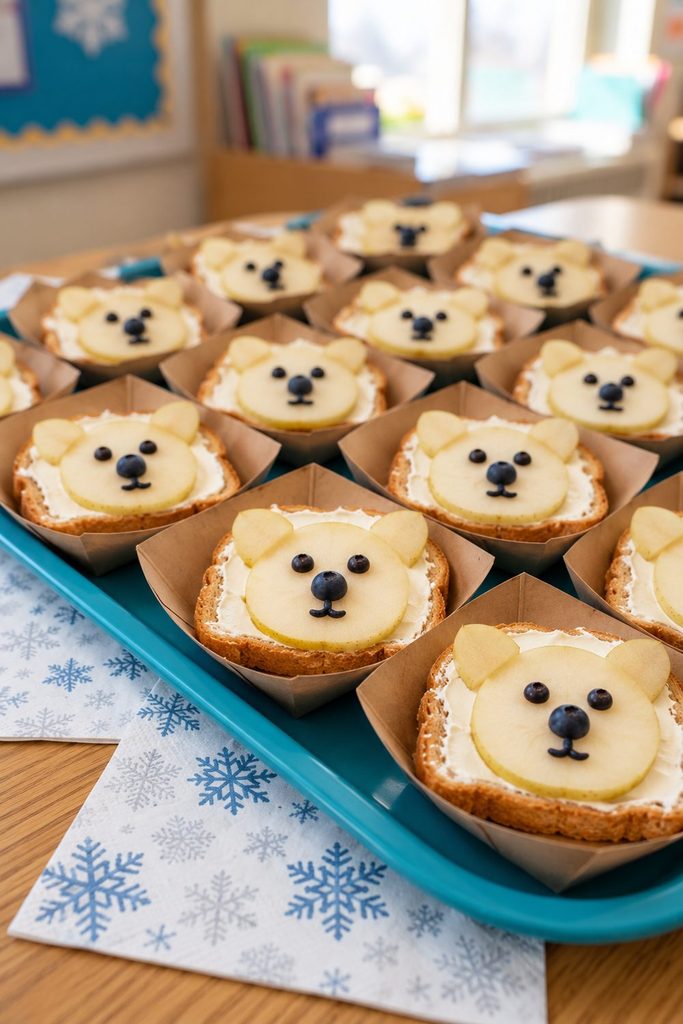 Pear polar bear faces with blueberry details on cream cheese toast in individual paper boats.